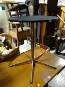 A small chrome leg & column black top circular side table