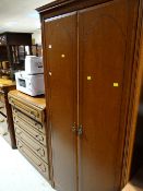 Dark wood effect two-door wardrobe together with a similar chest of five drawers
