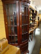 A modern dark wood floor standing corner cupboard with bevelled glazed upper & two-door cupboard