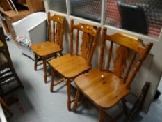Three honey pine kitchen chairs together with a loom-style armchair
