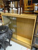 A vintage lightwood glass sliding door bookcase