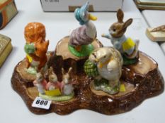Five Beswick Beatrix Potter figures on a log effect stand