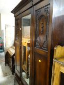An Edwardian single mirror door wardrobe with single drawer to base
