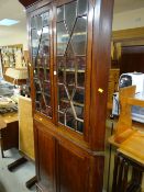 An antique mahogany standing corner cupboard with astragal glazed four-shelf top & two-door cupboard