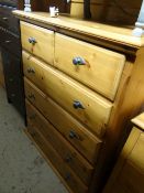 A honey pine chest of drawers with two short above four long with grey metal effect handles