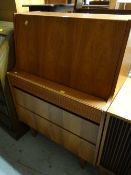 A vintage compact pull down three-drawer bureau