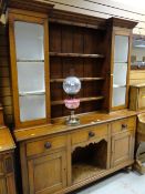 Early twentieth century light oak dresser with central shelving flanked by single glass door