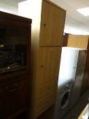 A tall narrow lightwood IKEA cupboard & drawer unit