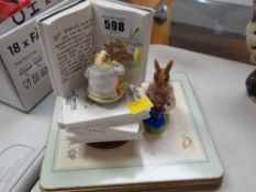 Beatrix Potter table mats, a Schmid Jeremy Fisher musical figure & Royal Doulton 'Dollie'
