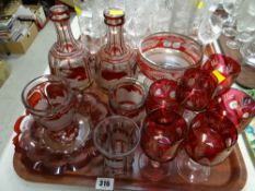 A tray of various etched ruby glass items including decanters, goblets etc