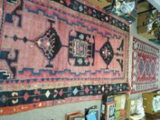 Iran pink and black ground woven woollen carpet, 224 x 133 cms approximately and an Indian woven