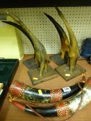 Two decorative cow horns and four bone animals on bases