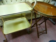 Mahogany twin handled tray on folding stand and two brass effect tea trollies