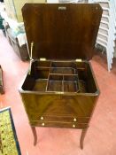 A REPRODUCTION CROSSBANDED MAHOGANY STANDING SEWING CABINET, lift-up lid with interior sliding