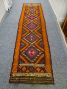 A SUZNI KILIM RUNNER CARPET having Greek Key running patterns in vibrant and wine colours with a