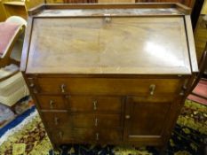 A MAHOGANY FALL FRONT BUREAU with railed top, the base with an unusual arrangement of seven