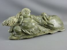 A LARGE CARVED GREEN HARDSTONE BUDAI, the Chinese folklore 'Figure of Contentment' hauling his