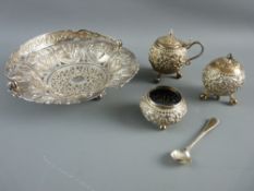 AN INDIA WHITE METAL SWING HANDLED BASKET and a three piece cruet set, the basket pierced with