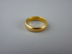 A TWENTY TWO CARAT GOLD MEDIUM WIDTH WEDDING BAND, 5.6 grms