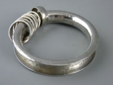 A STYLISH MID CENTURY SILVER BANGLE with additional looped ring decoration, London 1963, 2.4 troy