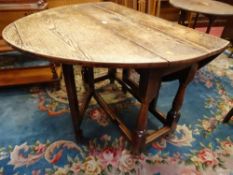 AN ANTIQUE OAK GATE LEG DINING TABLE, the peg joined sub frame on turned and block supports and