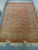 A PERSIAN WOOLLEN CARPET, multi-bordered on a rust ground with central repeating pattern and