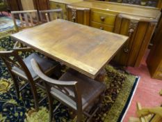 A VINTAGE OAK DINING SUITE of sideboard, draw leaf table and four chairs, all having carved detail