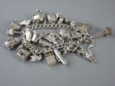 A SILVER CHARM BRACELET WITH TWENTY SEVEN CHARMS including moving and opening items, 2.3 troy ozs