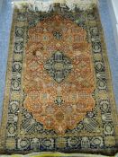 A FINE SILK QUOOM RUG having a three row border, rust ground centre with medallion and floral design