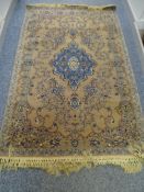 AN ISFAHAN WOOL RUG, mushroom ground with blue and red shaped and scrolled centre with surrounding