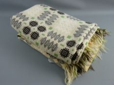 A TRADITIONAL WELSH WOOLLEN BLANKET with 'Derw Product' label, sand coloured with green, grey and