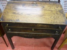AN ANTIQUE OAK DICKENS STYLE DESK, the slope front with brass escutcheon and iron strap hinges and