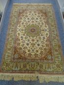 AN ISAFAHAN WOOL RUG, three row floral panel with centre triple tiered panel of flowers in greens