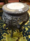 A CARVED CHINESE HARDWOOD STAND with pink marble inset top, 47 cms high, 27 cms diameter