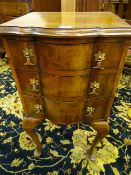 AN ANTIQUE STYLE WALNUT CHEST ON LEGS, the top with shaped edge moulding over three serpentine front