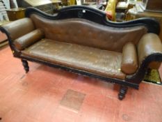 A LATE VICTORIAN SCROLL ENDED COUCH, the ebonized timber with shaped back and turned supports with