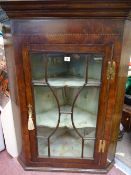 A GEORGIAN OAK & MAHOGANY WALL HANGING CORNER CUPBOARD having a stepped cornice and canted sides