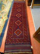 A HAND KNOTTED MESHWANI RUNNER CARPET, red and blue ground with repeating diamond central pattern