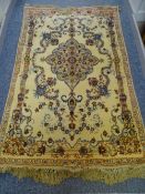 AN ISFAHAN WOOL RUG, fawn ground with centre shaped floral panel and surrounding flowers, 1.65 x 1.