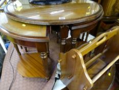 Circular nest of five tables with leather tooled tops and a polished magazine rack