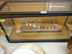 Glass cased Oriental string instrument