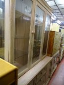 Three door glazed display cabinet with base cupboards and drawers and a matching two door glazed