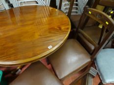 Polished wooden circular table on centre supports and with six matching rexine seated chairs