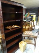 A reproduction mahogany tall bookcase together with a vintage oak tea trolley, ethnic carved stool
