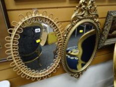 A vintage oval bamboo framed mirror together with another oval ornate gilt framed mirror