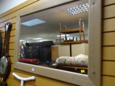 A modern pine framed mirror together with a vintage oval mahogany bevelled wall mirror