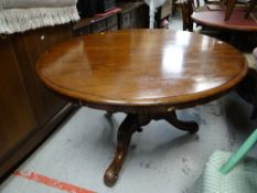 An antique mahogany tilt-top tripod dining table