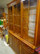 A reproduction yew wood bookcase cupboard three-door glazed top above a three drawer, three cupboard