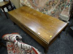 A vintage oak narrow low drop leaf coffee table