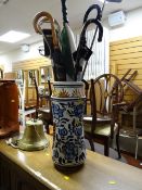 A continental ceramic stick / umbrella stand & contents including shooting stick, walking sticks